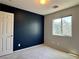 Bedroom featuring a dark accent wall and natural light from the exterior window at 9165 Beauchamp Ave, Las Vegas, NV 89148