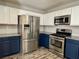 Kitchen with stainless appliances, granite counters and white and blue cabinets at 9165 Beauchamp Ave, Las Vegas, NV 89148