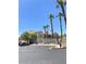 Exterior view of condo buildings with palm trees, landscaping, parking, and access gates at 9470 Peace Way # 212, Las Vegas, NV 89147