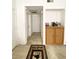 Hallway with light-colored carpet and white walls leading to a white paneled door with a tan-colored rug at 9470 Peace Way # 212, Las Vegas, NV 89147