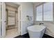 Chic bathroom featuring a modern standalone tub, black hexagonal floor tiles, and a well-organized closet at 9632 Cherry Canyon Ave, Las Vegas, NV 89129