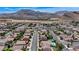 An elevated aerial view of a community with houses, roads, and mountainous scenery at 9632 Cherry Canyon Ave, Las Vegas, NV 89129