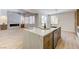 Bright and airy kitchen with a center island featuring stone countertop, sink, and view to living space at 9632 Cherry Canyon Ave, Las Vegas, NV 89129