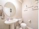 Bathroom features a pedestal sink, toilet, round mirror, and stylish decor at , Henderson, NV 89044