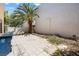 The backyard features tile flooring, a trash can, a medium sized tree, and light colored walls at 10348 Cherry Brook St, Las Vegas, NV 89183