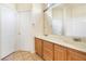 This is a bathroom with double sinks with wooden cabinets, white doors and walls, and tiled floors at 10348 Cherry Brook St, Las Vegas, NV 89183