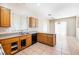 This kitchen features wood cabinets, a double sink, tile floors, and bright, natural lighting at 10348 Cherry Brook St, Las Vegas, NV 89183