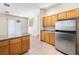 A view of kitchen with stainless steel appliances, wood cabinets, tile flooring, and a dining area at 10348 Cherry Brook St, Las Vegas, NV 89183