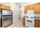 Galley-style kitchen featuring stainless steel appliances, wood cabinets, and tile flooring at 10348 Cherry Brook St, Las Vegas, NV 89183