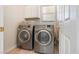 Laundry room with a modern washer and dryer, storage cabinet, and window at 10348 Cherry Brook St, Las Vegas, NV 89183