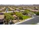 Wide aerial shot of a neighborhood featuring green spaces and well-maintained homes with red tiled roofs at 10584 Peach Creek St, Las Vegas, NV 89179