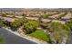 An aerial view shows houses in a neighborhood, with ample green space and mature trees at 10584 Peach Creek St, Las Vegas, NV 89179