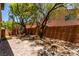 Backyard featuring a brick patio and mature trees with privacy fence and desert landscaping at 10584 Peach Creek St, Las Vegas, NV 89179