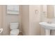 Cozy half bathroom features a pedestal sink, decorative mirror, and cabinet at 10584 Peach Creek St, Las Vegas, NV 89179