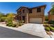 Charming two-story home featuring a stone facade, well-manicured landscaping, and an attached two-car garage at 10584 Peach Creek St, Las Vegas, NV 89179