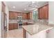 Well-equipped kitchen boasts wooden cabinetry, granite countertops, and stainless steel appliances at 10584 Peach Creek St, Las Vegas, NV 89179