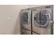 Modern laundry room featuring gray, front-load washer and dryer with sleek, contemporary design at 10584 Peach Creek St, Las Vegas, NV 89179