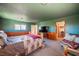 Spacious bedroom with wood paneling, a ceiling fan, and a comfortable sitting area at 1106 E Athens Ave, Henderson, NV 89015