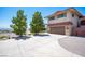 View of the exterior two-story home showing the garage, mature trees and a driveway at 1106 E Athens Ave, Henderson, NV 89015