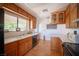 Charming kitchen featuring wood cabinets, tiled floors, modern appliances, and natural light at 1106 E Athens Ave, Henderson, NV 89015