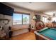 Comfortable living area with scenic window views, terracotta floors and a pool table for recreation at 1106 E Athens Ave, Henderson, NV 89015