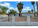 Cozy home featuring a white brick fence, desert landscaping and tall palms at 1804 David Ave, Las Vegas, NV 89101