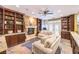 Bright living room featuring a fireplace, built-in shelving, and a cozy seating arrangement with a ceiling fan at 1844 Winners Cup Drive, Las Vegas, NV 89117