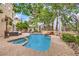 Private backyard pool with rock waterfall, spa, outdoor seating, and lush landscaping at 1844 Winners Cup Drive, Las Vegas, NV 89117