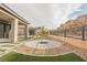 Backyard with artificial turf, paver accents, and a central fire pit area at 19 Desert Ivy Ln, Henderson, NV 89011