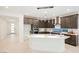 Modern kitchen featuring dark cabinetry, stainless steel appliances, and a large island with pendant lighting at 19 Desert Ivy Ln, Henderson, NV 89011