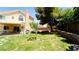 Grassy backyard featuring a covered patio with outdoor kitchen and mature trees at 2017 Shining Feather Ln, Las Vegas, NV 89134