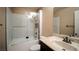 Bright bathroom featuring a marble tiled shower-over-tub with glass enclosure, and stone-look vanity at 2017 Shining Feather Ln, Las Vegas, NV 89134