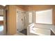 Bathroom featuring a glass-enclosed shower, soaking tub, and a window that lets in natural light at 2017 Shining Feather Ln, Las Vegas, NV 89134