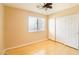 This bedroom has a ceiling fan, closet, and a window that lets in natural light over the hardwood flooring at 2017 Shining Feather Ln, Las Vegas, NV 89134
