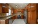 Spacious kitchen featuring stainless steel appliances, granite countertops, wood cabinets and tile floors at 2017 Shining Feather Ln, Las Vegas, NV 89134