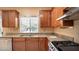 Bright kitchen with wood cabinets, granite countertops, and a stainless steel sink under a window at 2017 Shining Feather Ln, Las Vegas, NV 89134