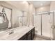 Bathroom featuring double sinks, walk-in shower with glass door, and modern fixtures at 209 Bennett Pointe Ave, Henderson, NV 89011