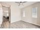A well-lit bedroom with tile floors, a ceiling fan and two windows, offering a bright and airy feel at 209 Bennett Pointe Ave, Henderson, NV 89011