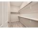 Walk-in closet with ample storage space, featuring multiple shelves and wood-style tile flooring at 209 Bennett Pointe Ave, Henderson, NV 89011