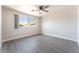 Large bedroom with wood floors, a ceiling fan, and a bright window at 2111 Hollow Oak Ave, North Las Vegas, NV 89031