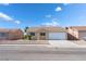 Inviting single-story home with a well-kept lawn and an attached two-car garage at 2111 Hollow Oak Ave, North Las Vegas, NV 89031
