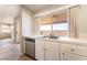 Kitchen featuring a double sink, white cabinets, stainless steel dishwasher, and an outdoor view at 2111 Hollow Oak Ave, North Las Vegas, NV 89031