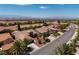 Aerial view of the neighborhood showcasing well-maintained homes, palm trees and mountain views at 2131 Waterton Rivers Dr, Henderson, NV 89044