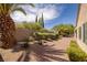 A well kept backyard with palm trees, desert landscaping, and a block wall at 2131 Waterton Rivers Dr, Henderson, NV 89044