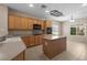 Bright kitchen featuring wood cabinets, an island, tile floors, and modern appliances at 2131 Waterton Rivers Dr, Henderson, NV 89044