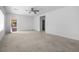 Bright living room with neutral carpet, ceiling fan, and entrance to the outdoor patio at 2131 Waterton Rivers Dr, Henderson, NV 89044