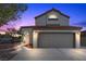 Charming two-story home with a well-manicured yard and a two-car garage at dusk at 2204 W San Miguel Ave, North Las Vegas, NV 89032