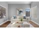 Cozy living room with a plush sofa, stylish artwork, and natural light from large windows at 2204 W San Miguel Ave, North Las Vegas, NV 89032