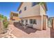 Exterior view of the home's back showing a gravel backyard with brick trim and patio furniture at 261 Fairway Woods Dr, Las Vegas, NV 89148