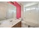 Bathroom featuring a cherry accent wall, vanity with wide mirror, toilet, and tub with shower at 261 Fairway Woods Dr, Las Vegas, NV 89148